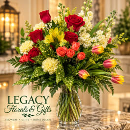 Mixed bouquet of roses, tulips, and carnations in a glass vase