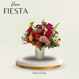 Mixed bouquet of bright flowers in a white vase