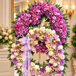 Lavender and pink floral wreath on an easel with a ribbon bow