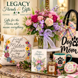 Mixed pink and purple bouquet in a glass vase with a ribbon, surrounded by Mother’s Day gifts