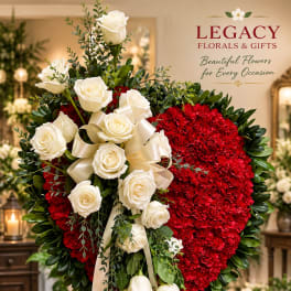 Heart-shaped floral standing spray with white roses and red blooms on a stand