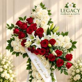 Standing floral cross of red and white roses with lilies on an easel
