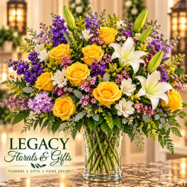 Yellow roses and white lilies in a clear glass vase