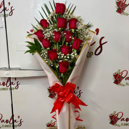 Bouquet of red roses with baby's breath wrapped in pink paper and a red ribbon