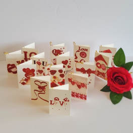 Red rose beside a spread of Valentine-themed greeting cards