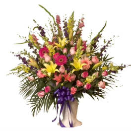 Large mixed bouquet with pink roses, lilies, and gerbera daisies in a wrapped base