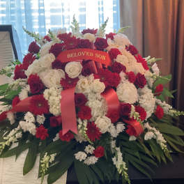 Large red and white funeral spray with a "Beloved Son" ribbon