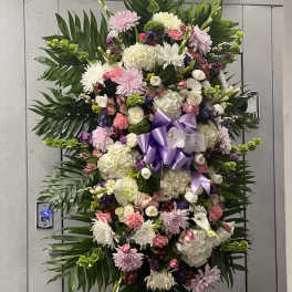 Large standing floral spray with pink, white, and purple blooms