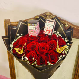 Bouquet of red roses with two perfume boxes and butterfly decorations