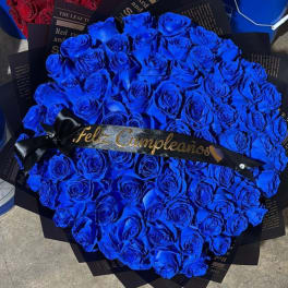 Bouquet of vivid blue roses with a black ribbon reading "Feliz Cumpleaños"