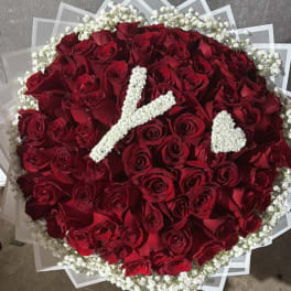 Round bouquet of red roses with white baby's breath accents