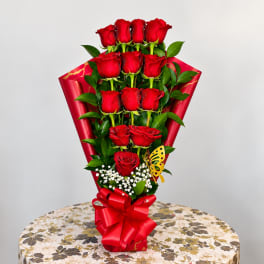 Bouquet of red roses wrapped in red paper with a bow