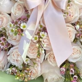 Bouquet of pale pink and white roses with a satin bow