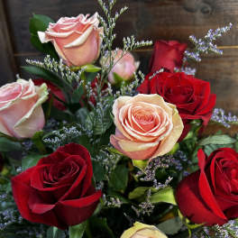 Bouquet of red and blush roses with small purple filler flowers