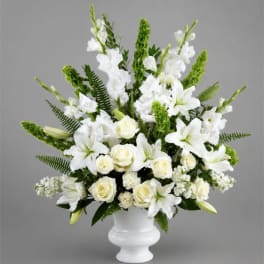White lilies and roses arranged in a white vase