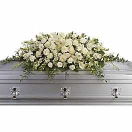 White floral casket spray on a gray casket