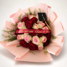 Bouquet of red and pink roses with a graduation cap ribbon