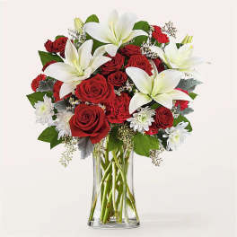 Red roses and white lilies in a clear glass vase