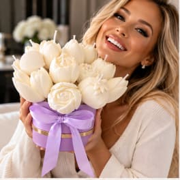 Woman holding a lavender box of cream-colored flower candles