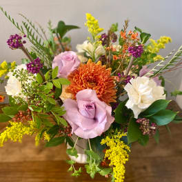 Mixed bouquet with lavender roses, orange chrysanthemum, and white carnations in a vase