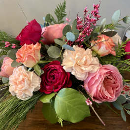 Mixed bouquet of pink and peach roses with carnations and greenery