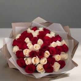 Bouquet of red and cream roses wrapped in layered paper