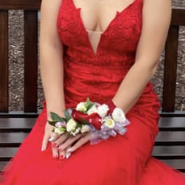 Woman in a red dress holding a floral wrist corsage