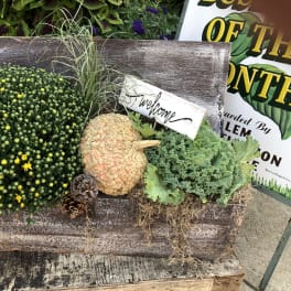 Fall planter with mums, kale, and a pumpkin in a rustic wooden box