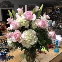 Pink roses and white hydrangeas arranged in a glass vase