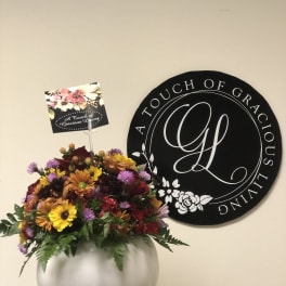 Mixed bouquet in a white vase with yellow, purple, and red flowers