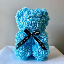 Blue teddy bear made of artificial roses with a black ribbon