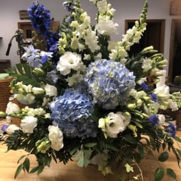 Large blue and white floral arrangement with tall spikes and hydrangeas