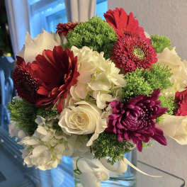 Bouquet of red and white flowers in a clear glass vase