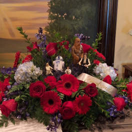 Large red floral arrangement with Star Wars figurines and a ribbon