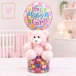 Pink teddy bear with a baby girl balloon and candy-filled base