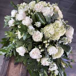 Large white floral arrangement with roses and hydrangeas