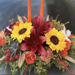 Colorful floral arrangement with sunflowers, red lilies, and orange roses