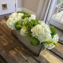 White and green floral arrangement in a rectangular wooden box