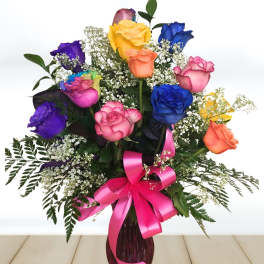 Colorful rose bouquet in a vase with a pink ribbon
