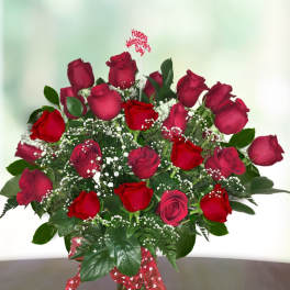 Bouquet of red roses in a glass vase with a Valentine topper