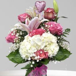 Pink and white bouquet with roses, hydrangea, and a lily in a vase