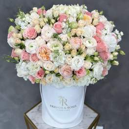 Large pastel bouquet of roses and white blooms in a white hatbox