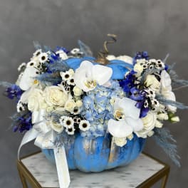Blue pumpkin-shaped arrangement with white orchids, roses, and small daisies