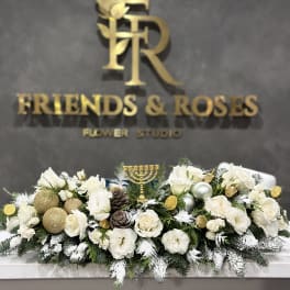 White floral centerpiece with gold ornaments and a menorah