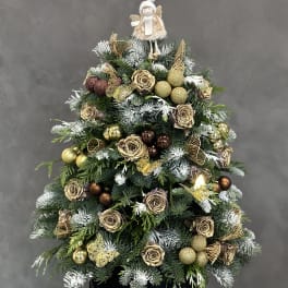 Christmas tree arrangement with gold roses and ornaments in a black box