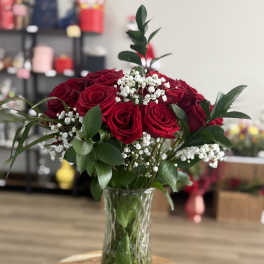 Red roses in a clear glass vase with white baby's breath