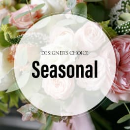 Soft pink and white roses in a floral arrangement with greenery