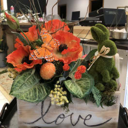 Orange poppy arrangement with a moss bunny in a wooden box