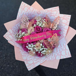 Pink and cream rose bouquet with butterfly decorations and a Valentine ribbon