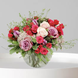 Bouquet of pink, red, and white roses in a glass vase
